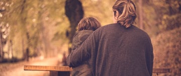 A woman and child stroll along a serene path, symbolizing family bonds amidst the challenges of migraines.