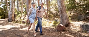 an elderly couple walks in the countryside with backpacks