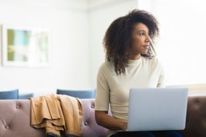 A woman working intently on her laptop, surrounded by a tidy desk, reflecting a professional and organized atmosphere.