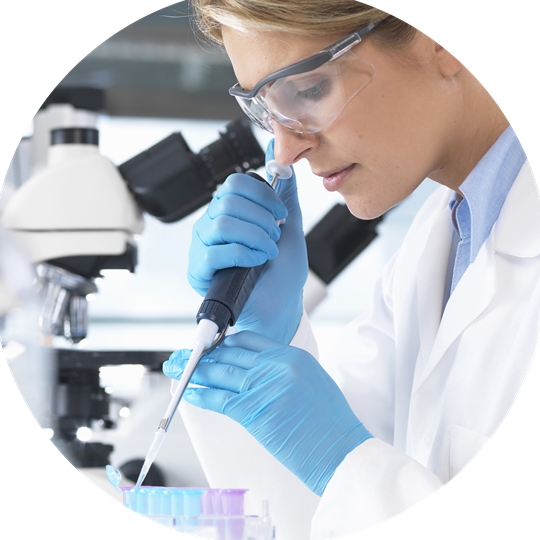 A woman in a lab coat examines a microscope, symbolizing research in biosimilar medicines.