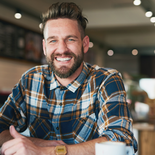 young smiling man in a plaid shirt