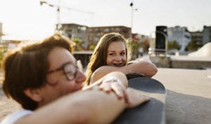 A couple enjoys skateboarding together, with "skateboarding is fun" displayed, promoting an educational program for kids.