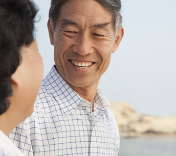 A man and woman are engaged in a cheerful exchange, smiling at one another, highlighting their positive connection.